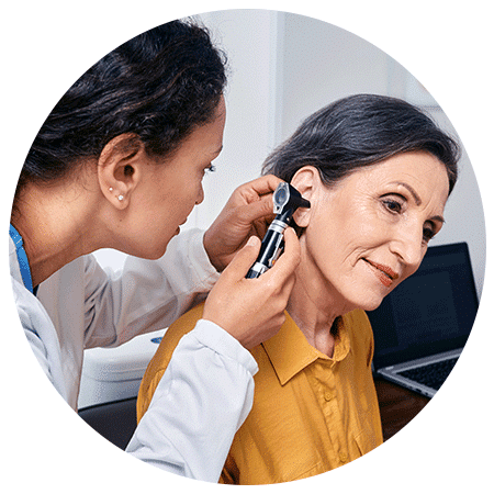doctor checking woman's ear using otoscope